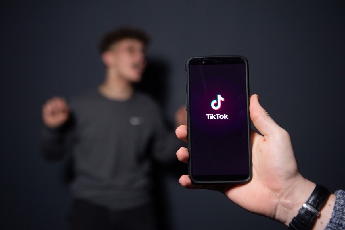 Influencer poses for a picture using the smart phone application TikTok.